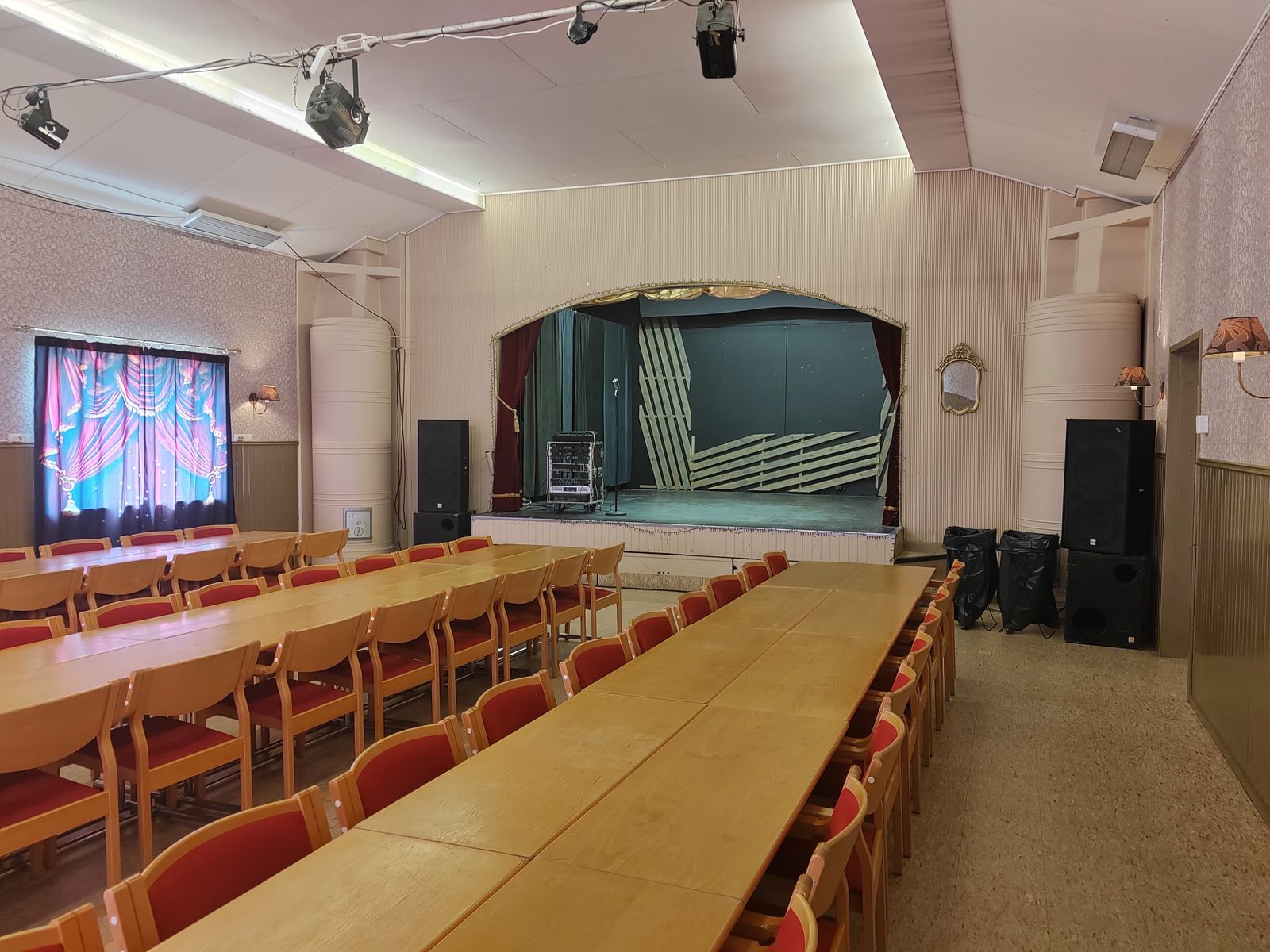 Juhlasalin pitkät pöydät ja näyttämö